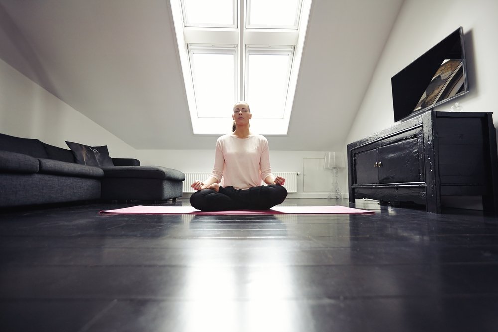 woman exercising yoga in living room