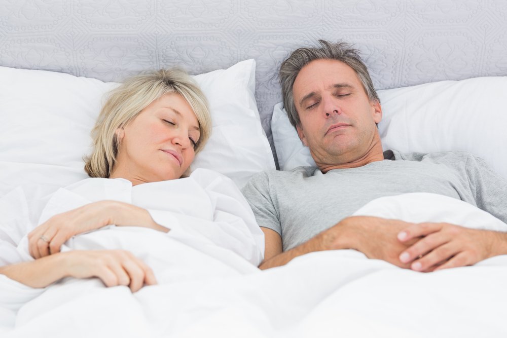 Couple sleeping peacefully in their bed at home